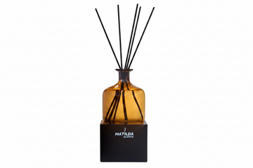 Reed diffuser with black sticks in a brown bottle on a white background, featuring the brand 'Matilda Scents'.